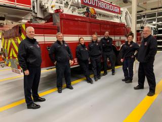 Fire fighters standing next fire truck